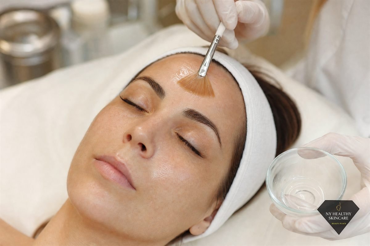 Esthetician applying a chemical peel solution with a fan brush at a Midtown Manhattan studio